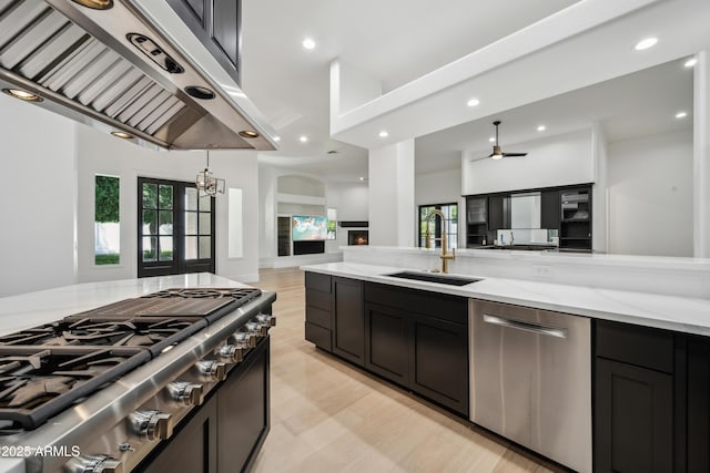 kitchen with appliances with stainless steel finishes, a sink, extractor fan, open floor plan, and ceiling fan