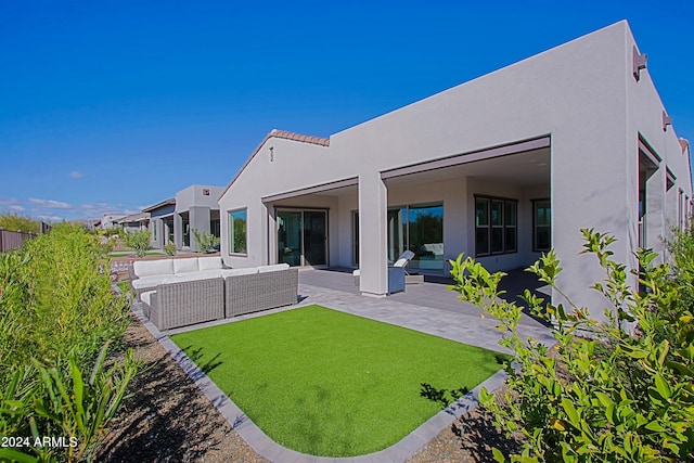 rear view of property featuring an outdoor hangout area, a yard, and a patio