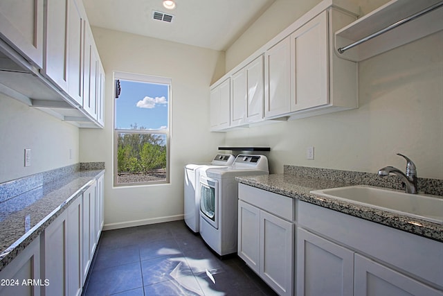 laundry room featuring separate washer and dryer, cabinets, sink, and dark tile flooring