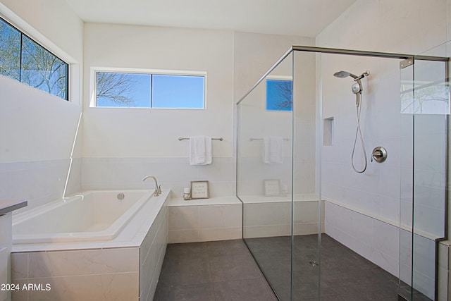 bathroom featuring tile flooring, independent shower and bath, and plenty of natural light