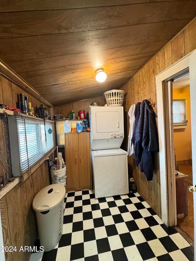 clothes washing area with wood ceiling, stacked washer and clothes dryer, and wood walls