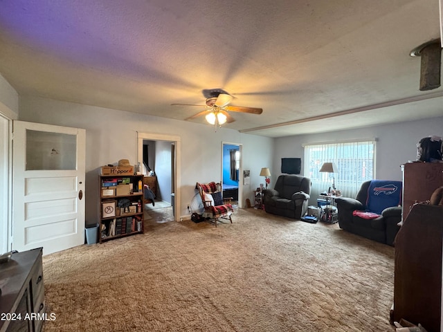 interior space with ceiling fan, a textured ceiling, and carpet