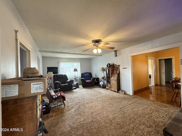 living area featuring a ceiling fan, a textured ceiling, and carpet flooring