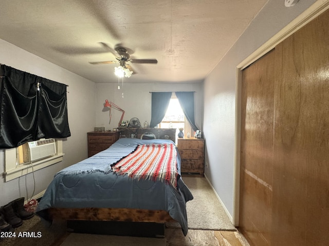 bedroom featuring a closet, baseboards, a textured ceiling, cooling unit, and a ceiling fan