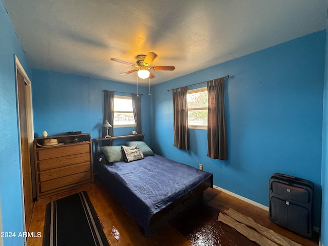 bedroom with dark hardwood / wood-style floors and ceiling fan