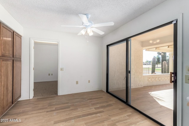 unfurnished bedroom with ceiling fan, a closet, a textured ceiling, and light hardwood / wood-style flooring