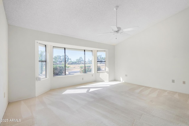 carpeted spare room featuring ceiling fan, a textured ceiling, and vaulted ceiling