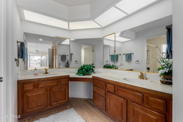 bathroom featuring a shower, a skylight, hardwood / wood-style floors, and vanity