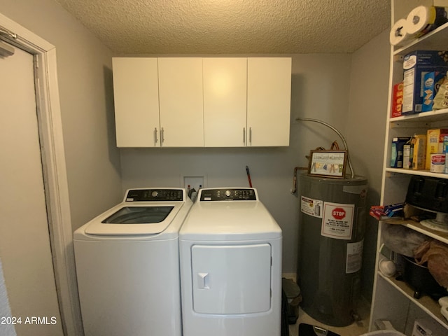 washroom with washing machine and clothes dryer, water heater, cabinets, and a textured ceiling