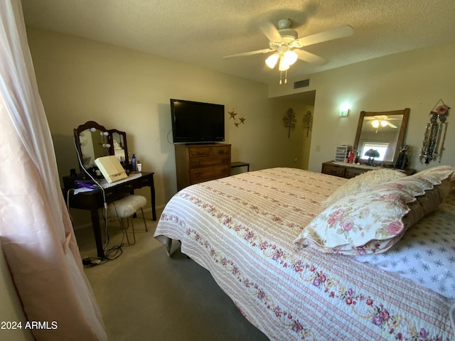 carpeted bedroom with ceiling fan and a textured ceiling