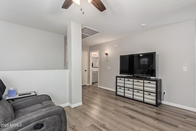 living room featuring light hardwood / wood-style flooring and ceiling fan