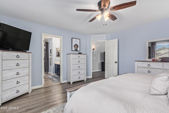 bedroom with dark wood-type flooring, ceiling fan, and ensuite bathroom