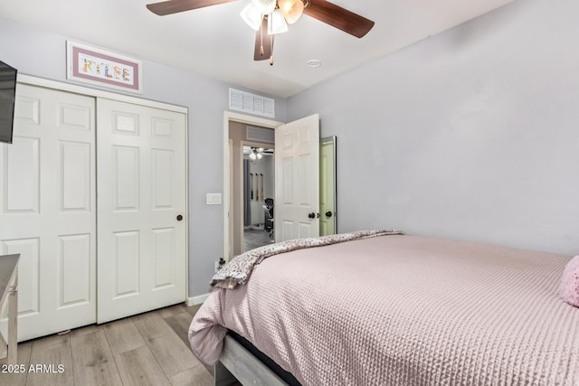 bedroom featuring ceiling fan, a closet, and light hardwood / wood-style flooring