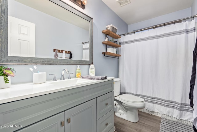 bathroom with vanity, hardwood / wood-style floors, curtained shower, and toilet