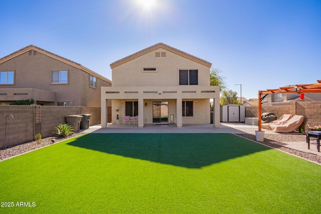 rear view of house featuring a storage unit, a yard, a pergola, and a patio