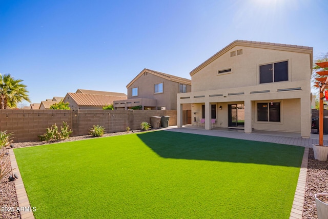 rear view of property featuring a patio area and a lawn