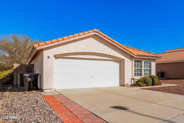 view of property exterior with a garage and central air condition unit