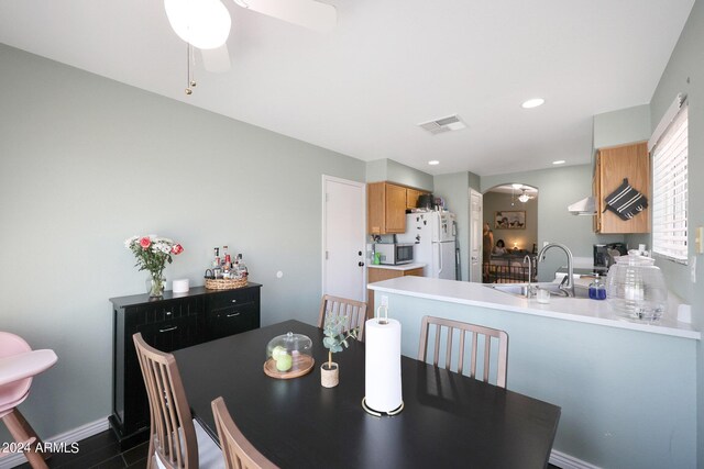 kitchen with under cabinet range hood, stainless steel appliances, light countertops, and a sink