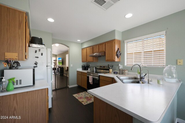 kitchen featuring a sink, under cabinet range hood, plenty of natural light, arched walkways, and appliances with stainless steel finishes