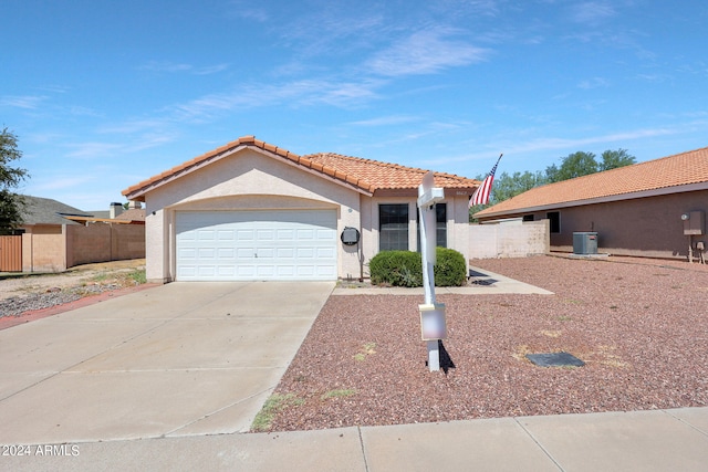 view of front of house with fence, concrete driveway, central AC unit, stucco siding, and an attached garage