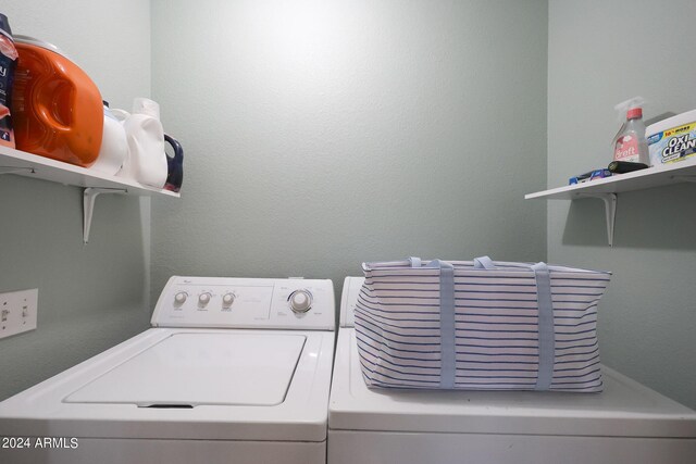 clothes washing area featuring washing machine and clothes dryer and laundry area