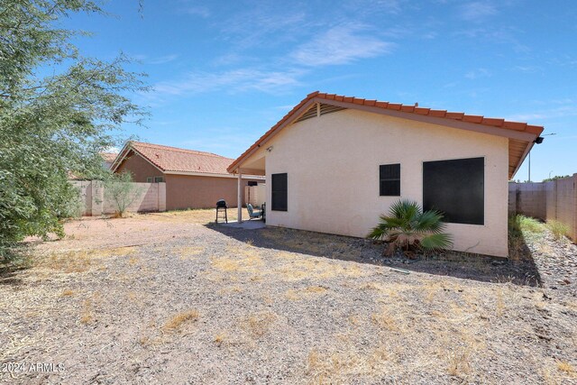 rear view of house featuring stucco siding and a fenced backyard