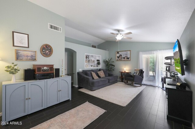 living area featuring baseboards, dark wood-type flooring, a ceiling fan, and vaulted ceiling