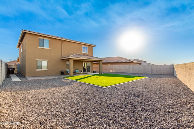 rear view of house with a lawn and a patio area