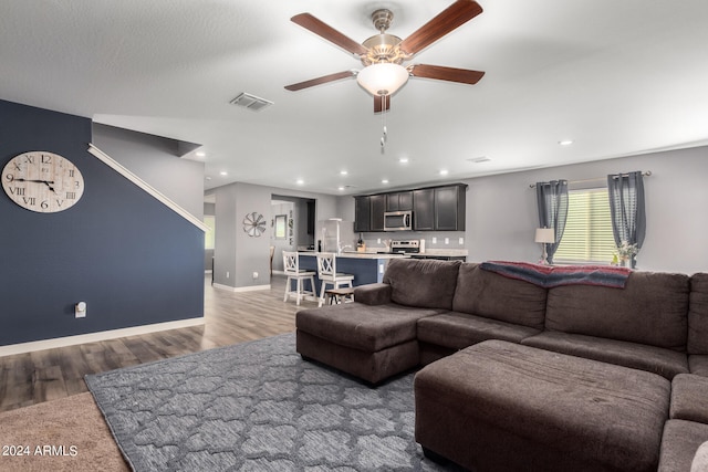 living room with dark hardwood / wood-style flooring and ceiling fan