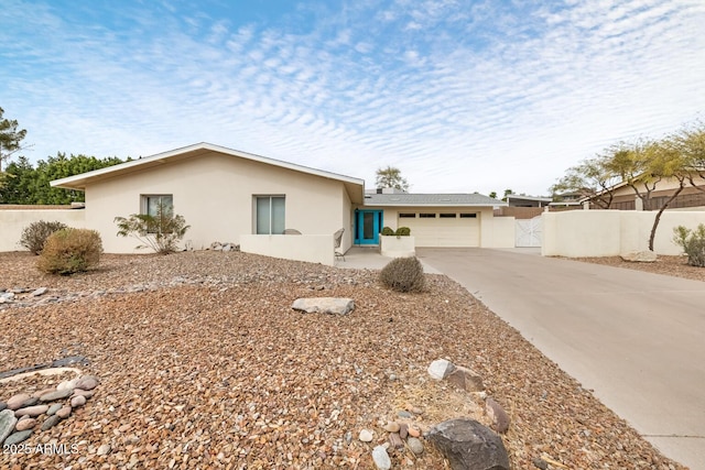 single story home featuring a garage, fence, driveway, a gate, and stucco siding