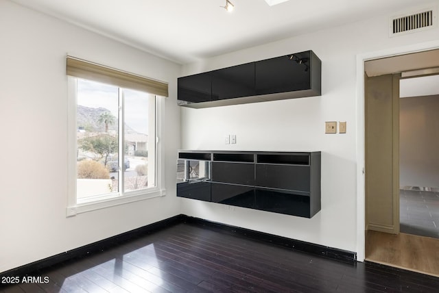 interior details with wood finished floors, visible vents, and baseboards