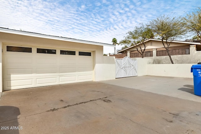 garage featuring fence and a gate