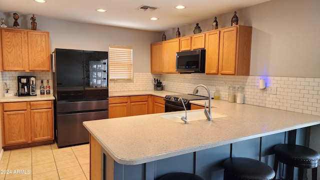 kitchen with stainless steel refrigerator, kitchen peninsula, backsplash, a breakfast bar area, and light tile patterned flooring