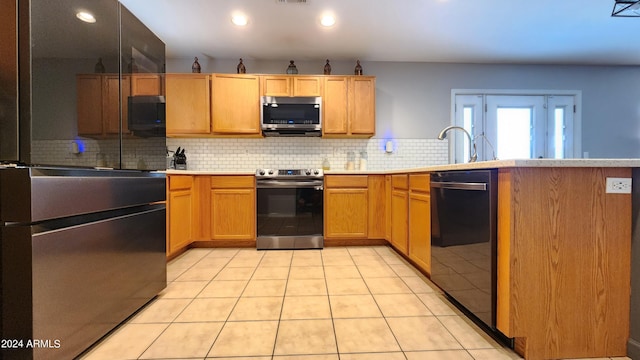 kitchen featuring light tile patterned floors, backsplash, appliances with stainless steel finishes, and sink