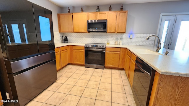 kitchen with decorative backsplash, sink, kitchen peninsula, and stainless steel appliances