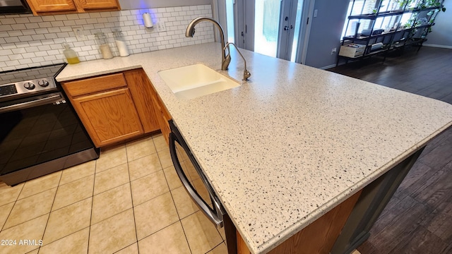 kitchen with sink, dishwasher, electric range, and decorative backsplash