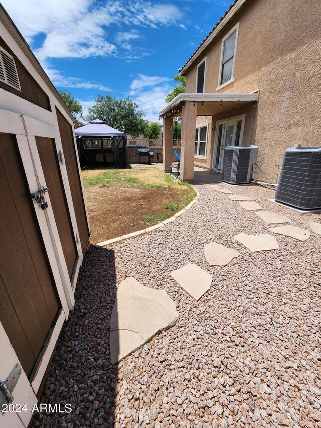 view of yard featuring a gazebo and central air condition unit