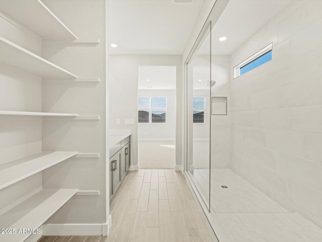 bathroom with vanity, hardwood / wood-style floors, and a tile shower