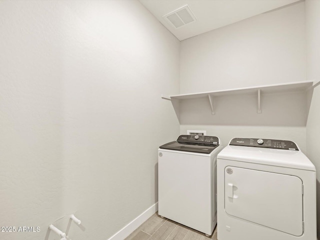 laundry room featuring light hardwood / wood-style floors and washing machine and dryer