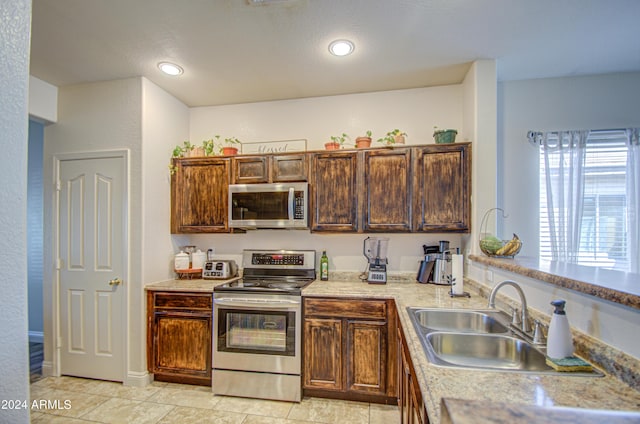 kitchen with light countertops, recessed lighting, a sink, and stainless steel appliances