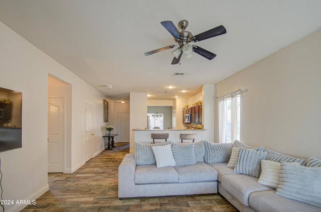living room featuring baseboards, recessed lighting, a ceiling fan, visible vents, and wood finished floors
