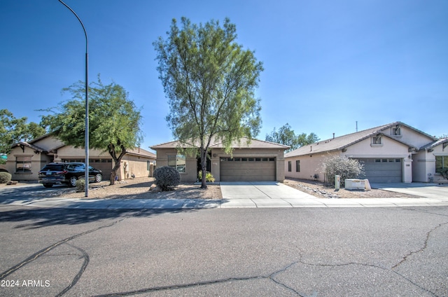 ranch-style house with driveway, a garage, and stucco siding