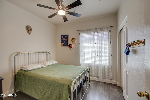 bedroom with a closet, ceiling fan, baseboards, and wood finished floors
