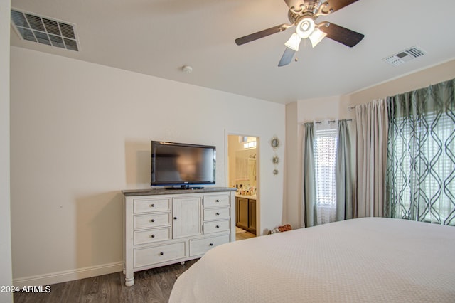 bedroom with visible vents, baseboards, ensuite bathroom, and dark wood-style floors