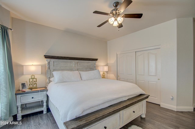 bedroom featuring dark wood-type flooring, a closet, baseboards, and a ceiling fan