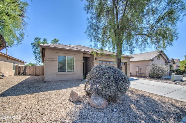 ranch-style home with stucco siding, fence, a tile roof, a garage, and driveway