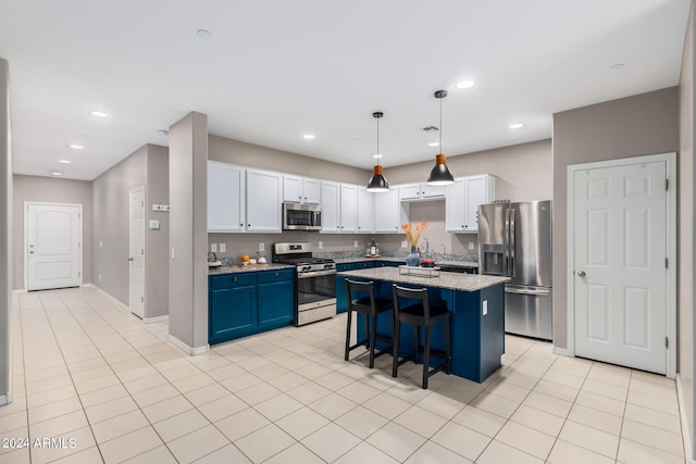 kitchen featuring a breakfast bar, a center island, white cabinetry, stainless steel appliances, and blue cabinets