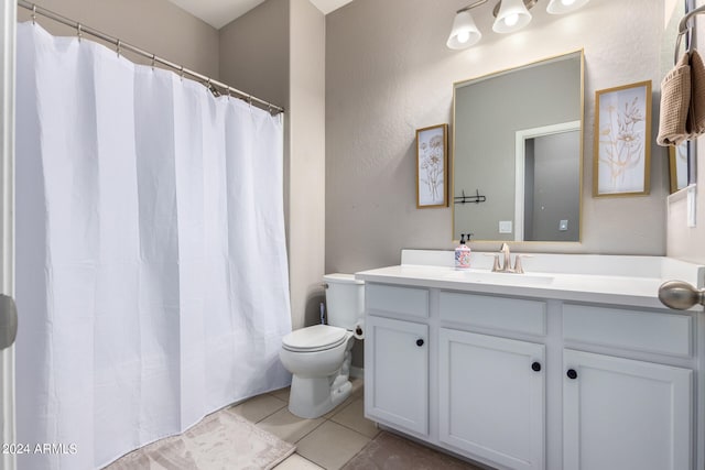 bathroom with walk in shower, vanity, toilet, and tile patterned floors