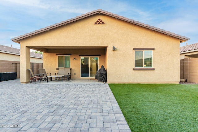 rear view of property with a lawn and a patio area