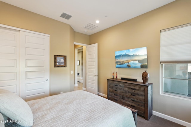 bedroom with dark carpet and a closet